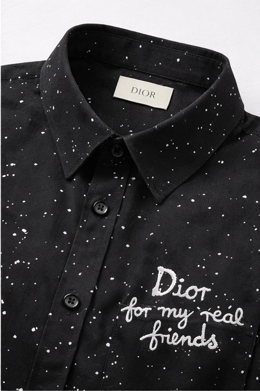 Dior featuring a speckled pattern and a white embroidered phrase on the pocket.